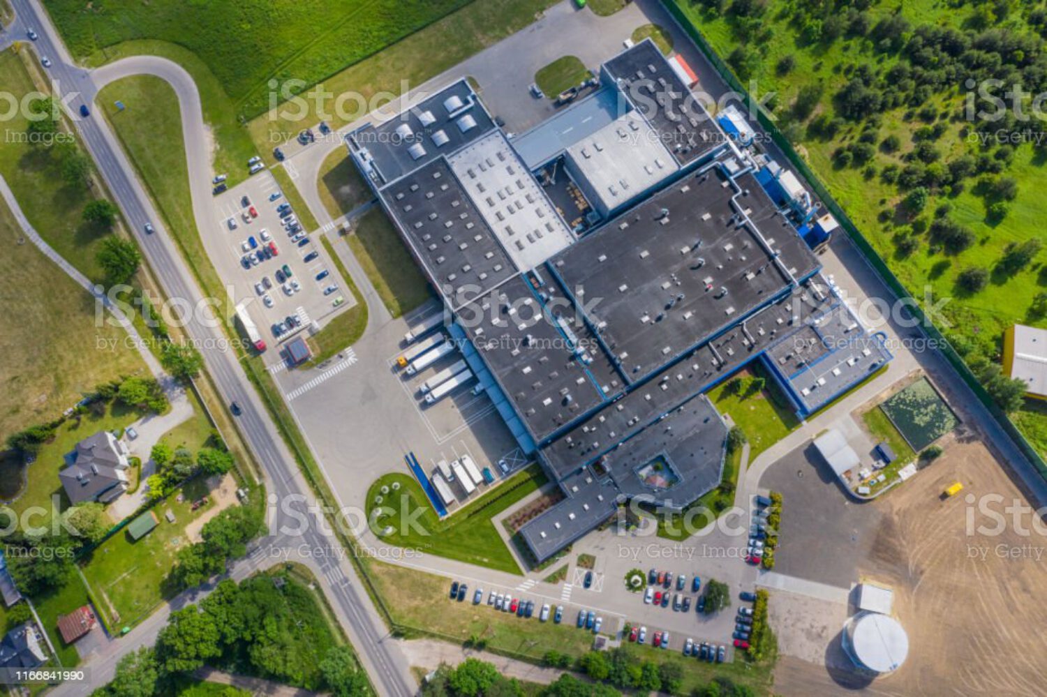 Aerial view of goods warehouse. Logistics center in industrial city zone from above. Aerial view of trucks loading at logistic center